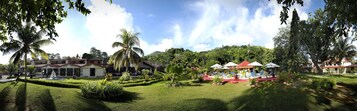 Um resort com piscina, palmeiras e um coreto.