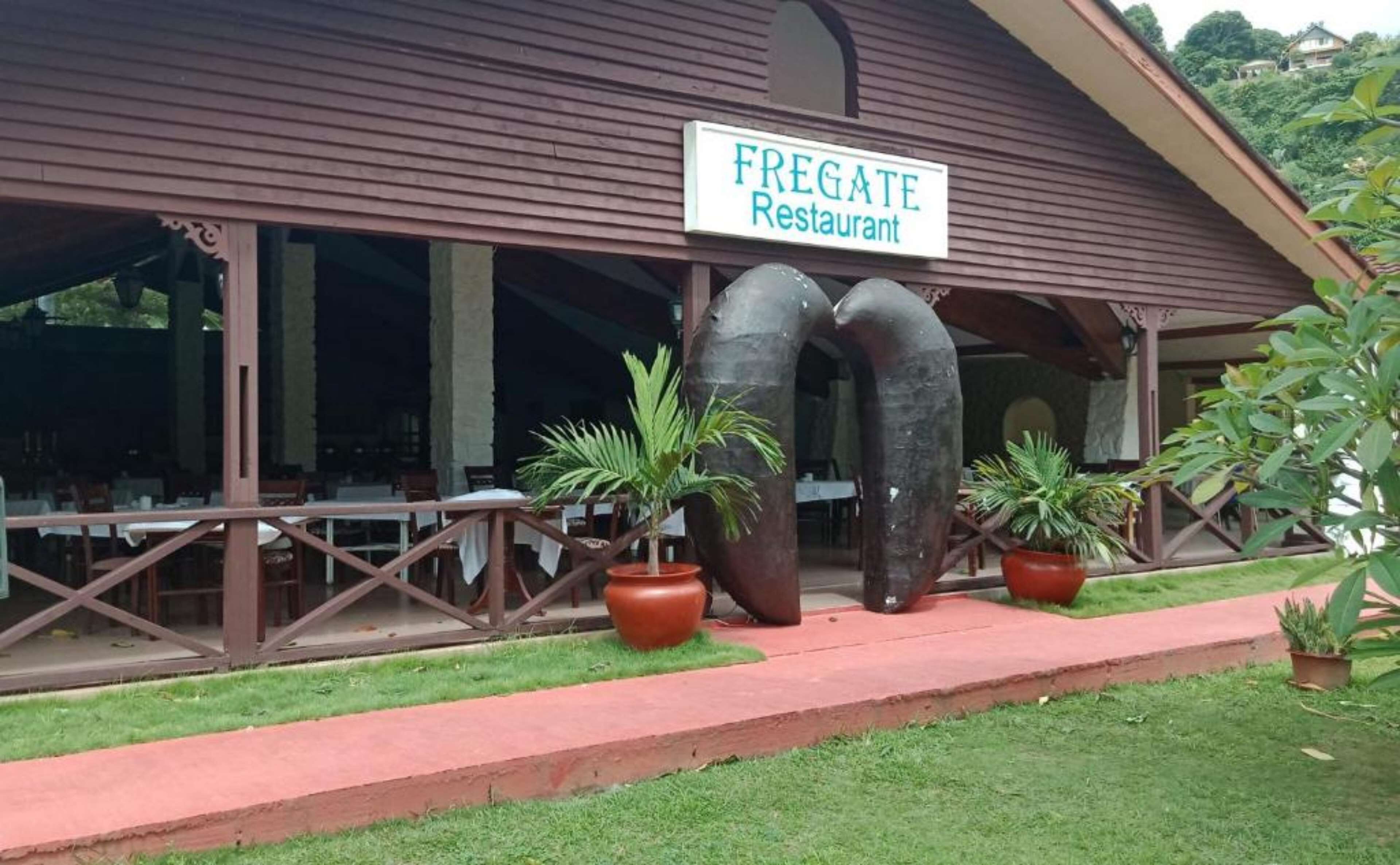 Un restaurante llamado 'FREGATE' con terraza y plantas en macetas.