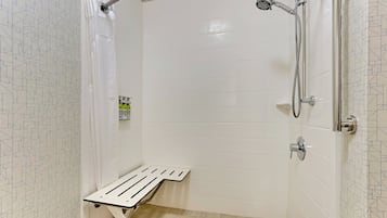 Une douche équipée d’un pommeau de douche à main, d’un flexible de douche et d’un porte-savon ou d’un étagère pour les produits de douche.