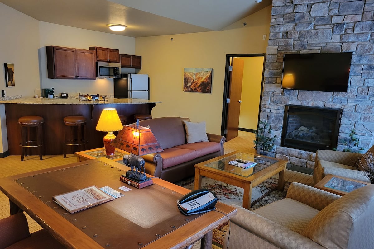 A living room with a sofa, coffee table, and a dining area with a lamp.