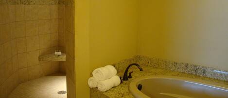 A bathroom with a bathtub, a shower, and a towel rack.