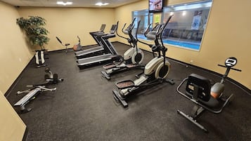 A gym with treadmills, elliptical machines, and a stationary bike.