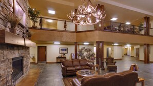 A spacious lobby with a stone fireplace, leather furniture, and a chandelier. - StoneCreek Lodge (Missoula)