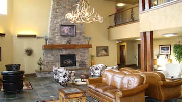 Relax in this inviting living area with a stone fireplace, leather sofas, and a chandelier.