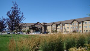 A hotel with a central entrance, multiple floors, and a parking lot. - StoneCreek Lodge (Missoula)