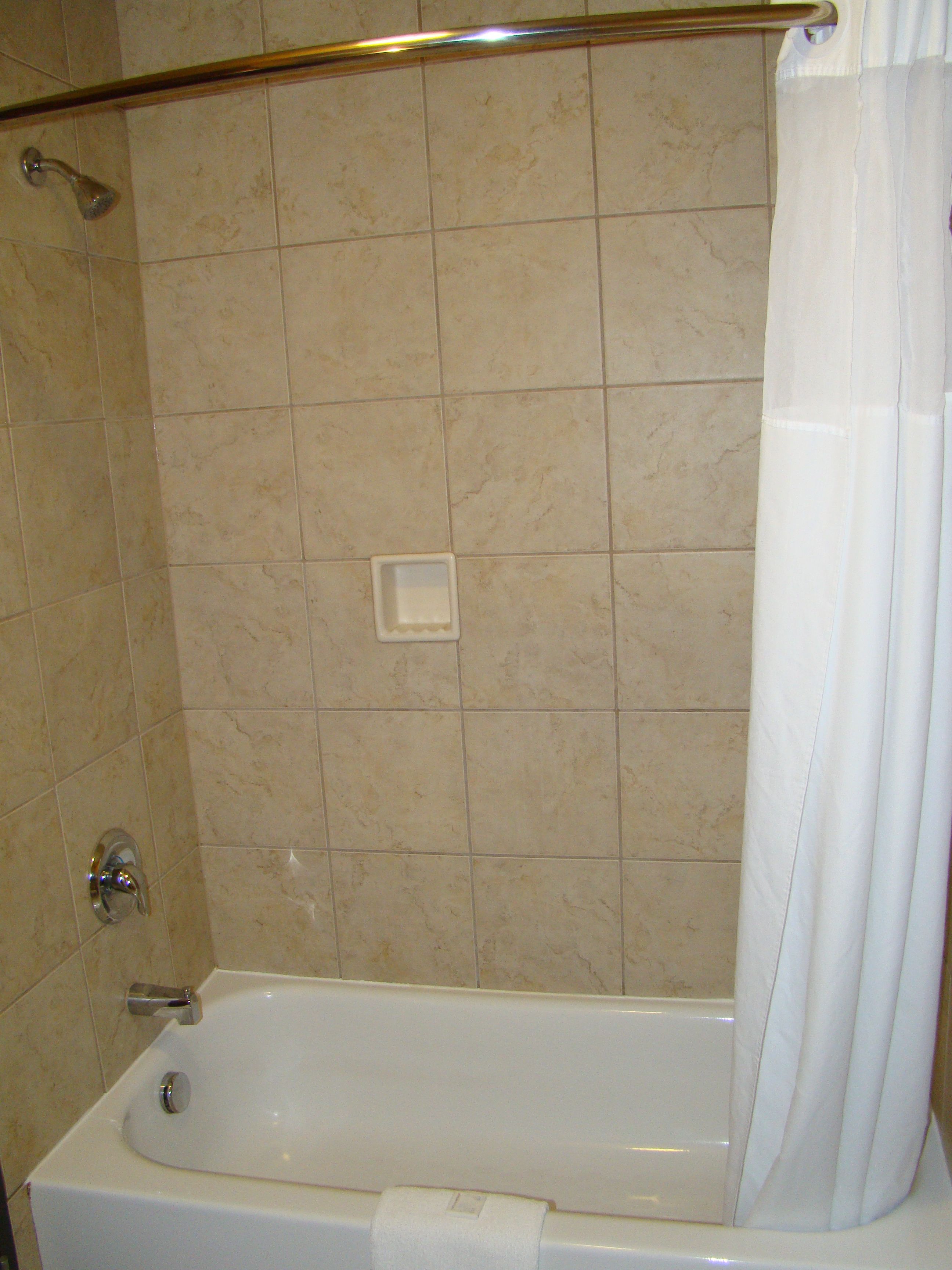 Ein Badezimmer mit einer Badewanne, einer Dusche und einem Handtrockner.