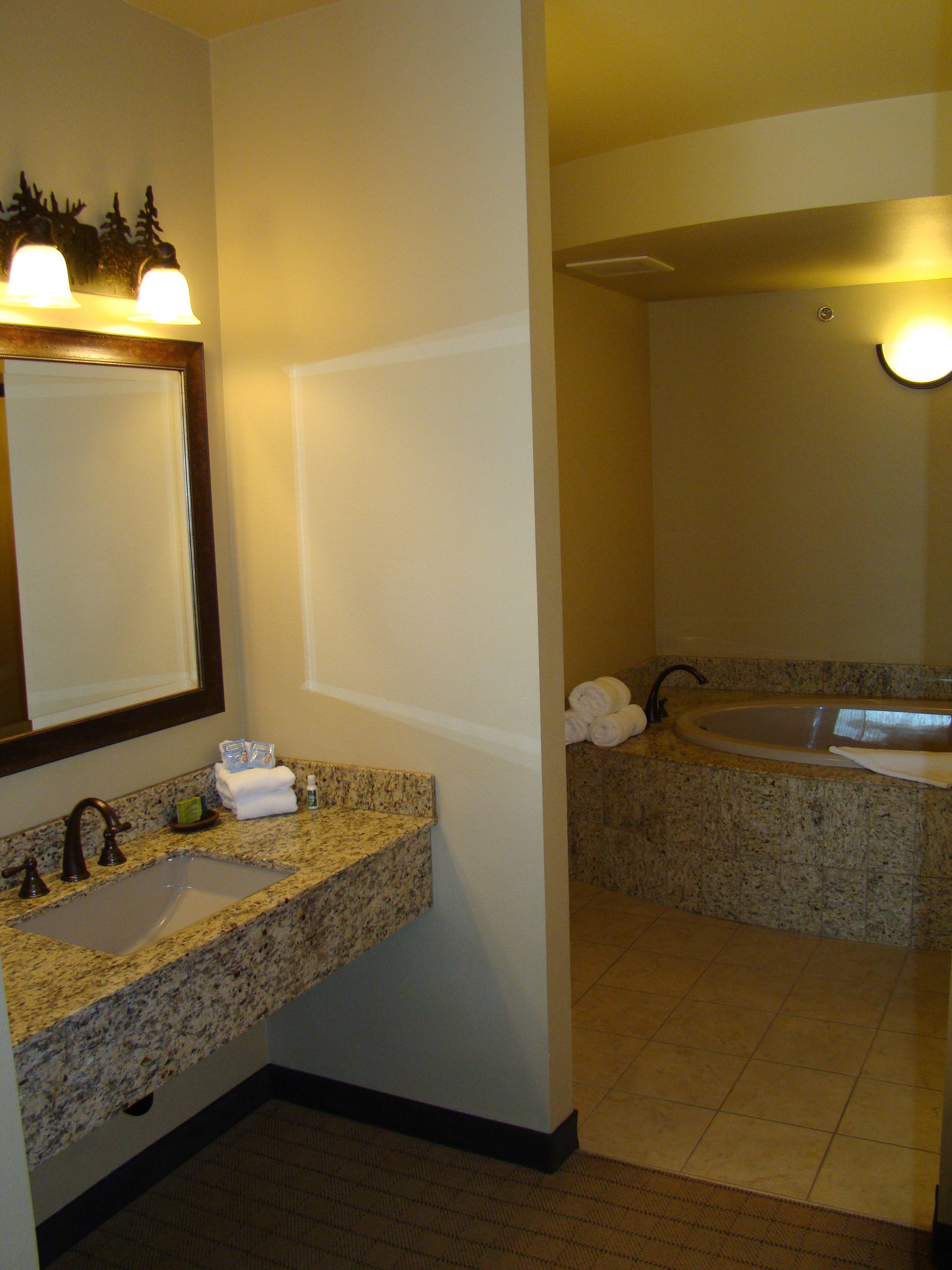 A bathroom with two sinks, a mirror, and a towel rack.