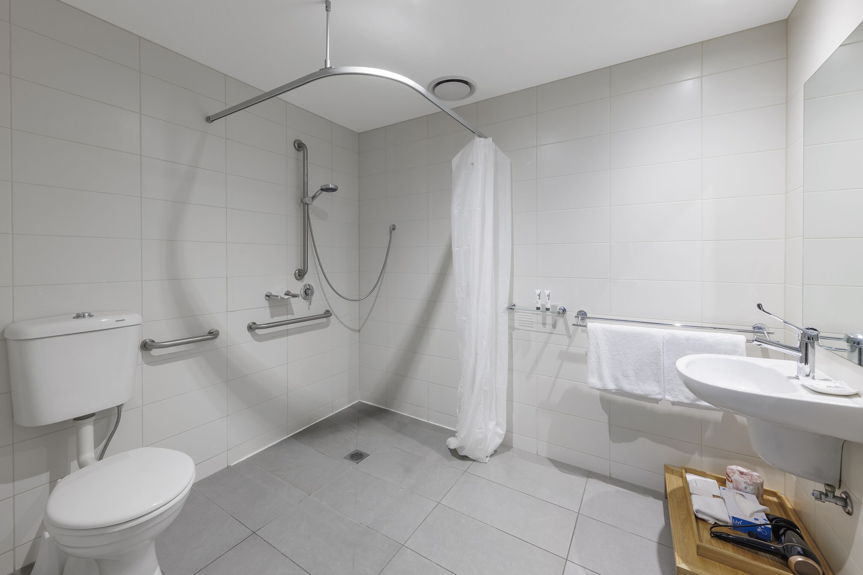 Un baño moderno con inodoro, ducha y lavamanos.