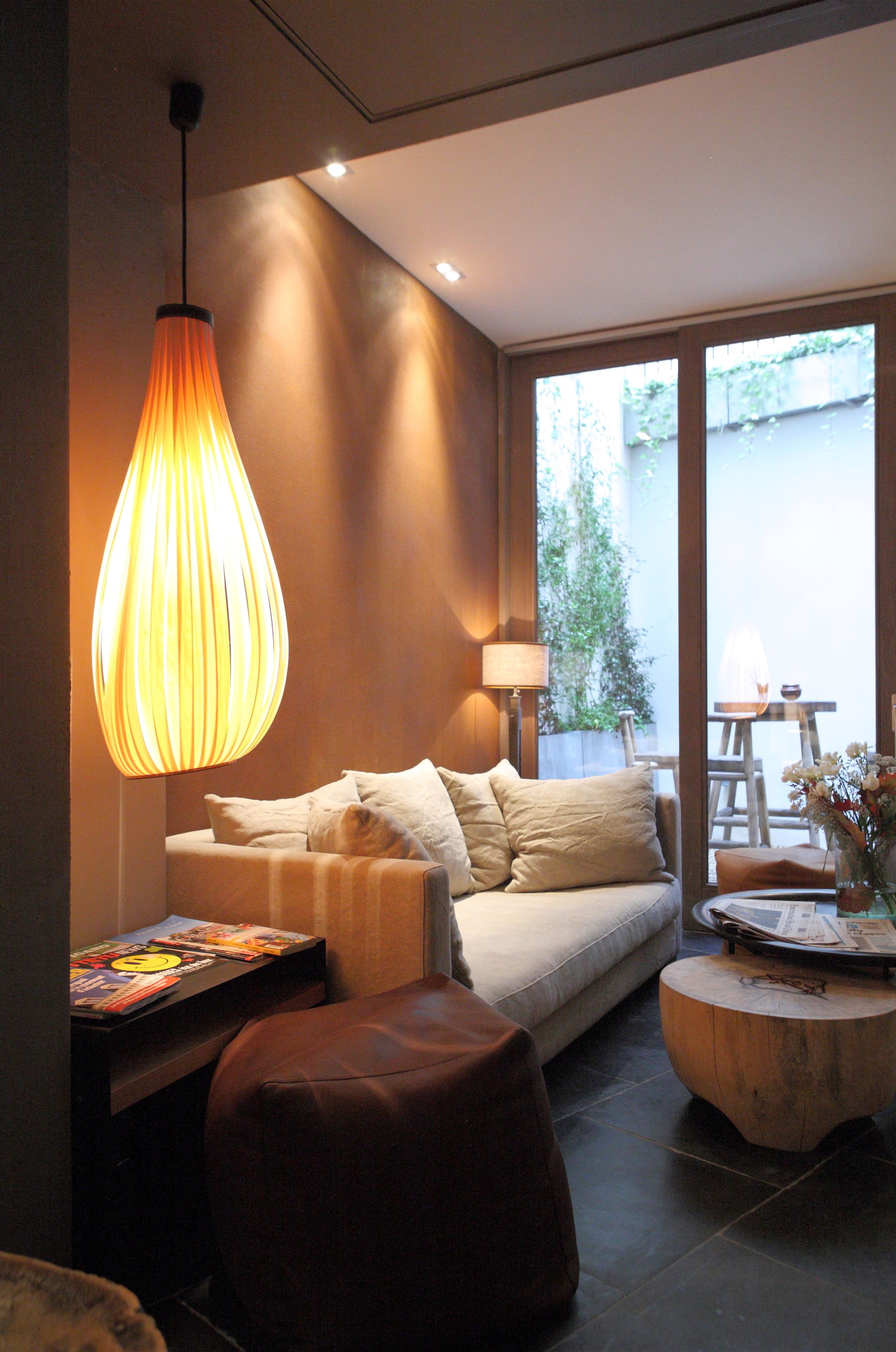 Un salon moderne avec un canapé, une table basse et un luminaire suspendu.
