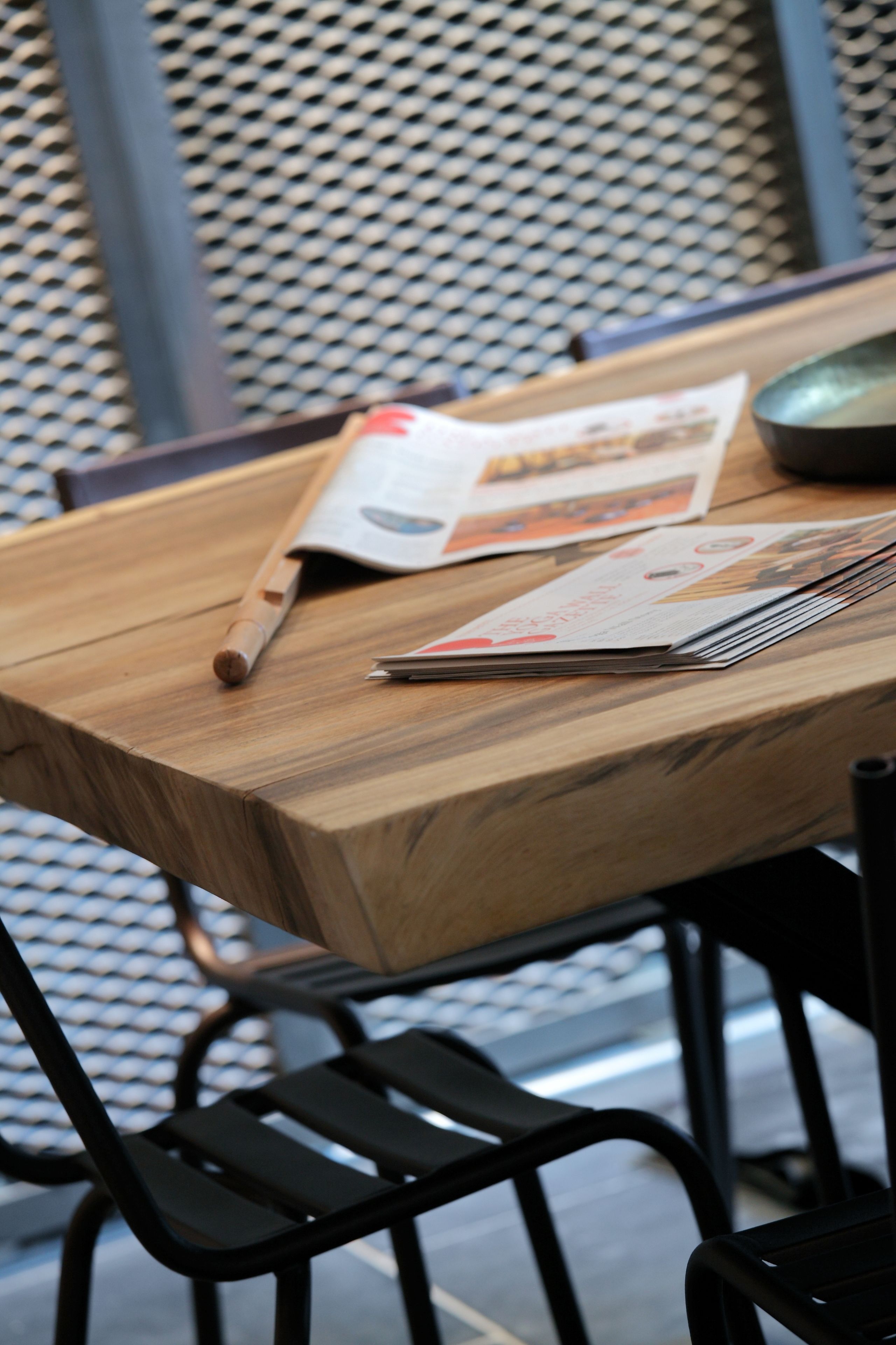Una mesa de madera con una revista, un bolígrafo y un ratón.