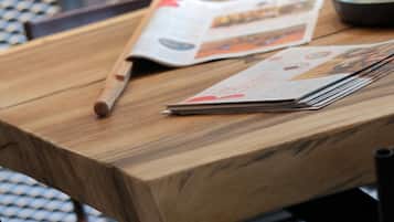 Una mesa de madera con una revista, un bolígrafo y un ratón.