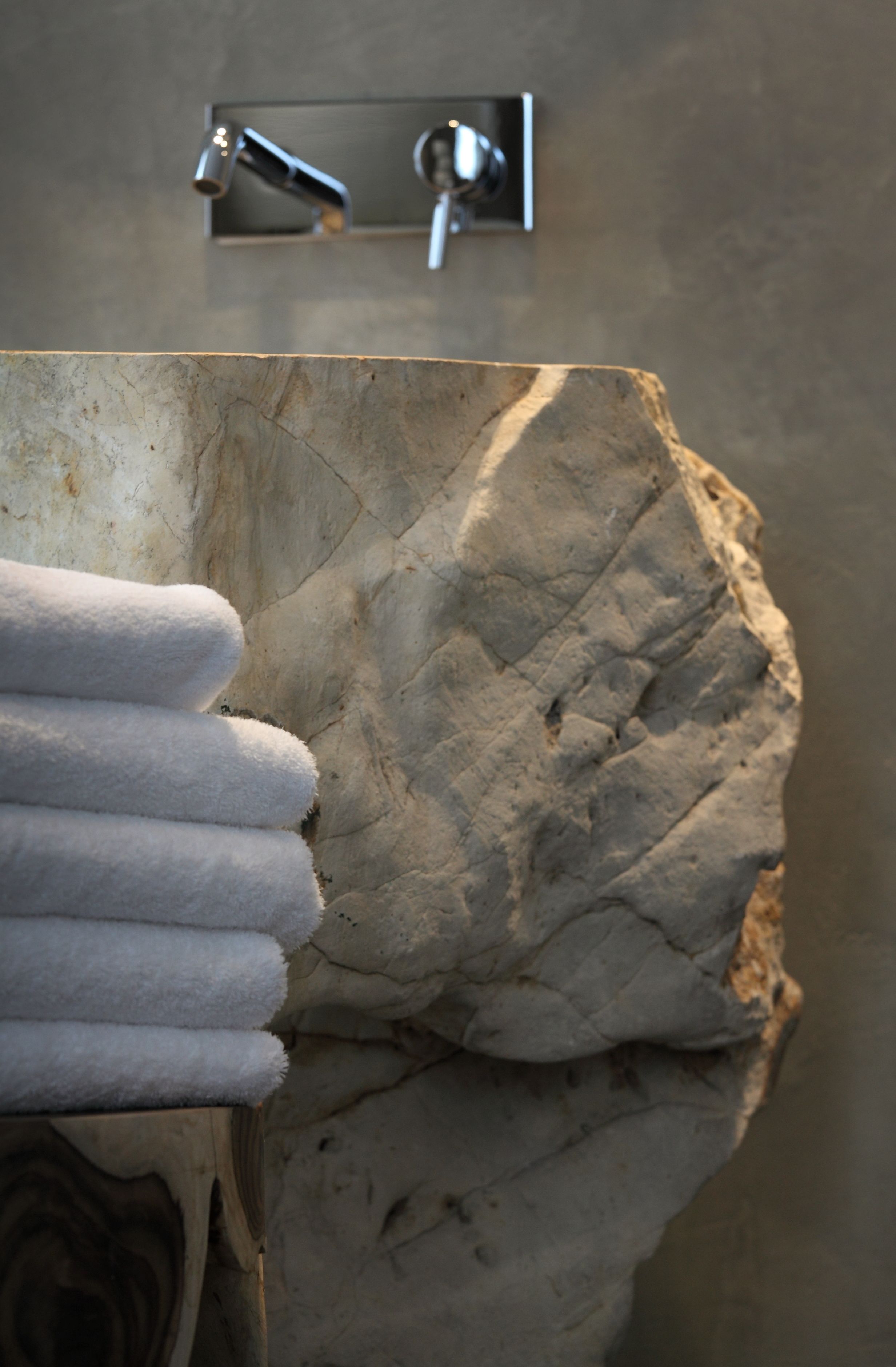Un lavabo de piedra con un sujetador de toallas.