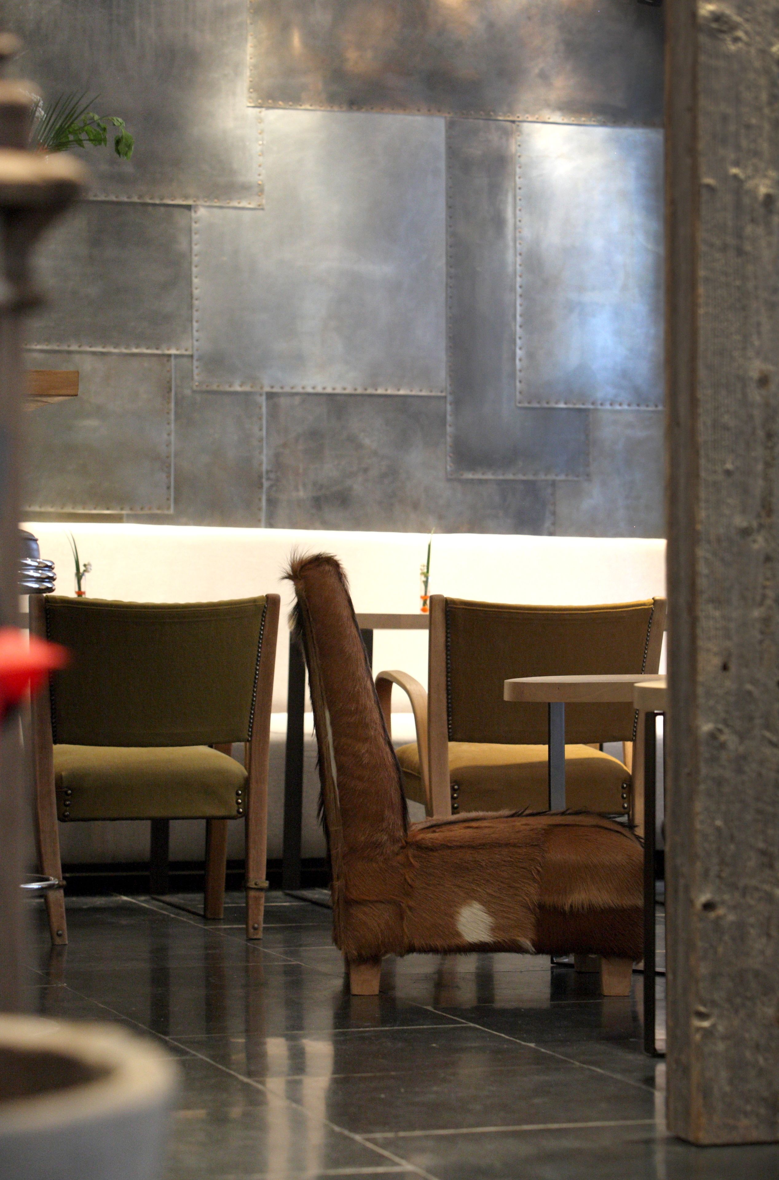 Een modern interieur met een zithoek, bestaande uit twee fauteuils met lederen bekleding en een bijzettafeltje.