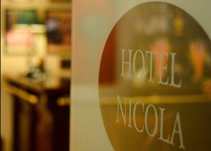 A blurred interior view of a hotel room with a visible sign reading "HOTEL NICOLA". - Nicola Hotel (Athens)