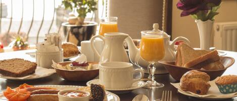 Desayuno con diversas opciones de comida, incluyendo tostadas, muffins y una cafetera.