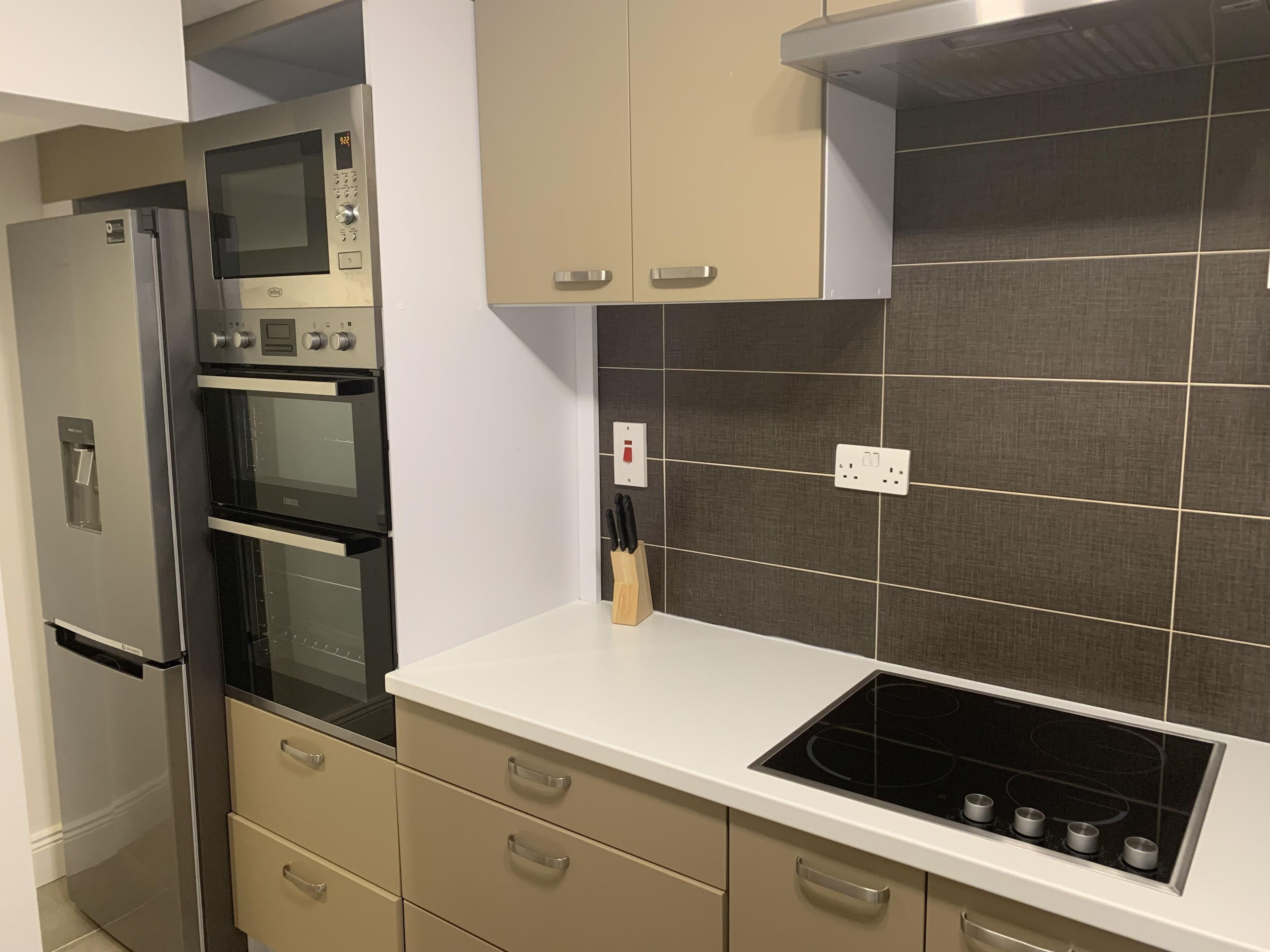 A modern kitchen with a built-in oven, microwave, and stovetop.