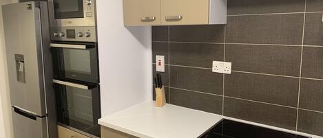 A modern kitchen with a built-in oven, microwave, and stovetop.
