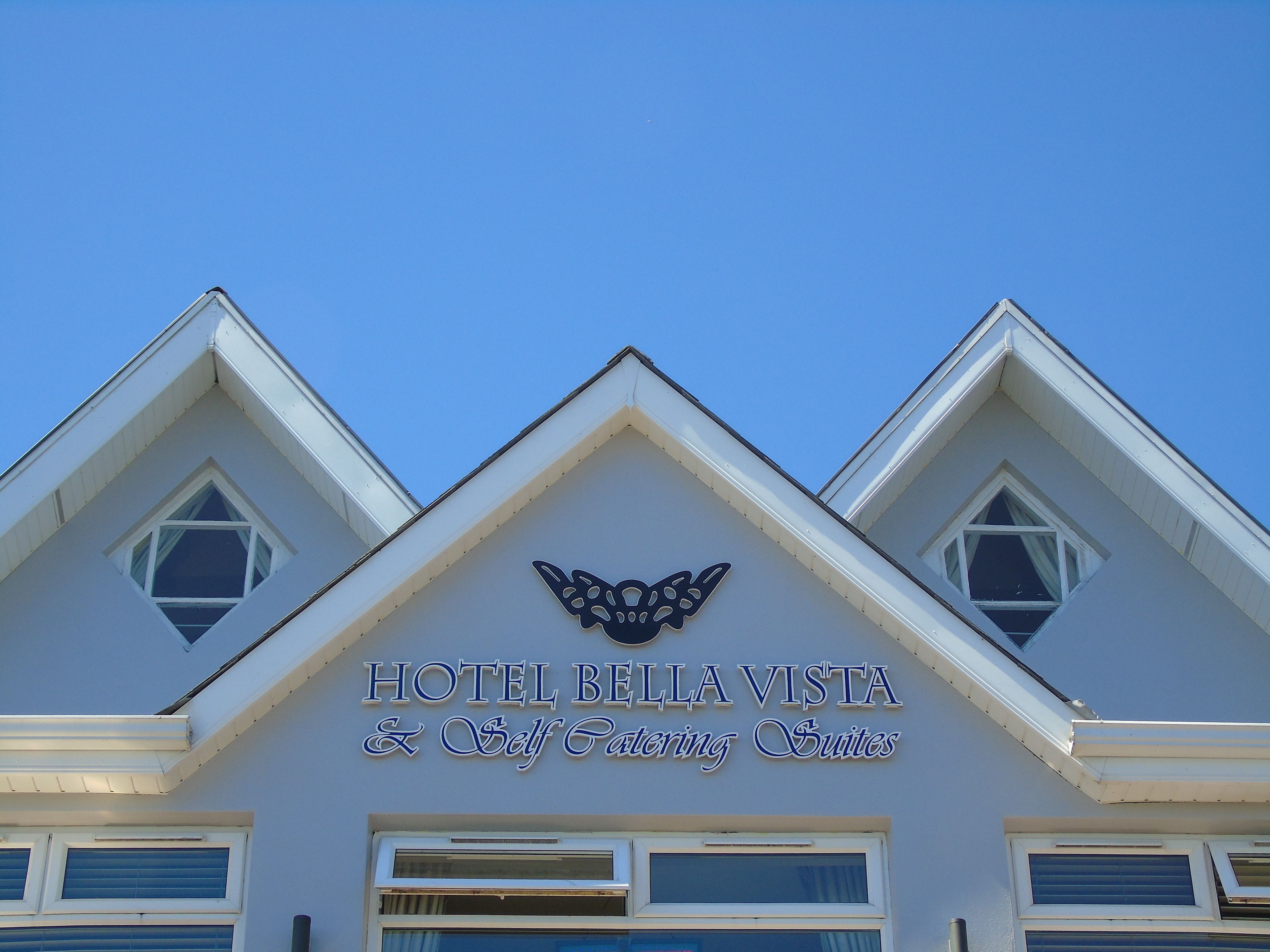 Un hotel llamado "Hotel Bella Vista" con un cartel que indica suites con cocina.
