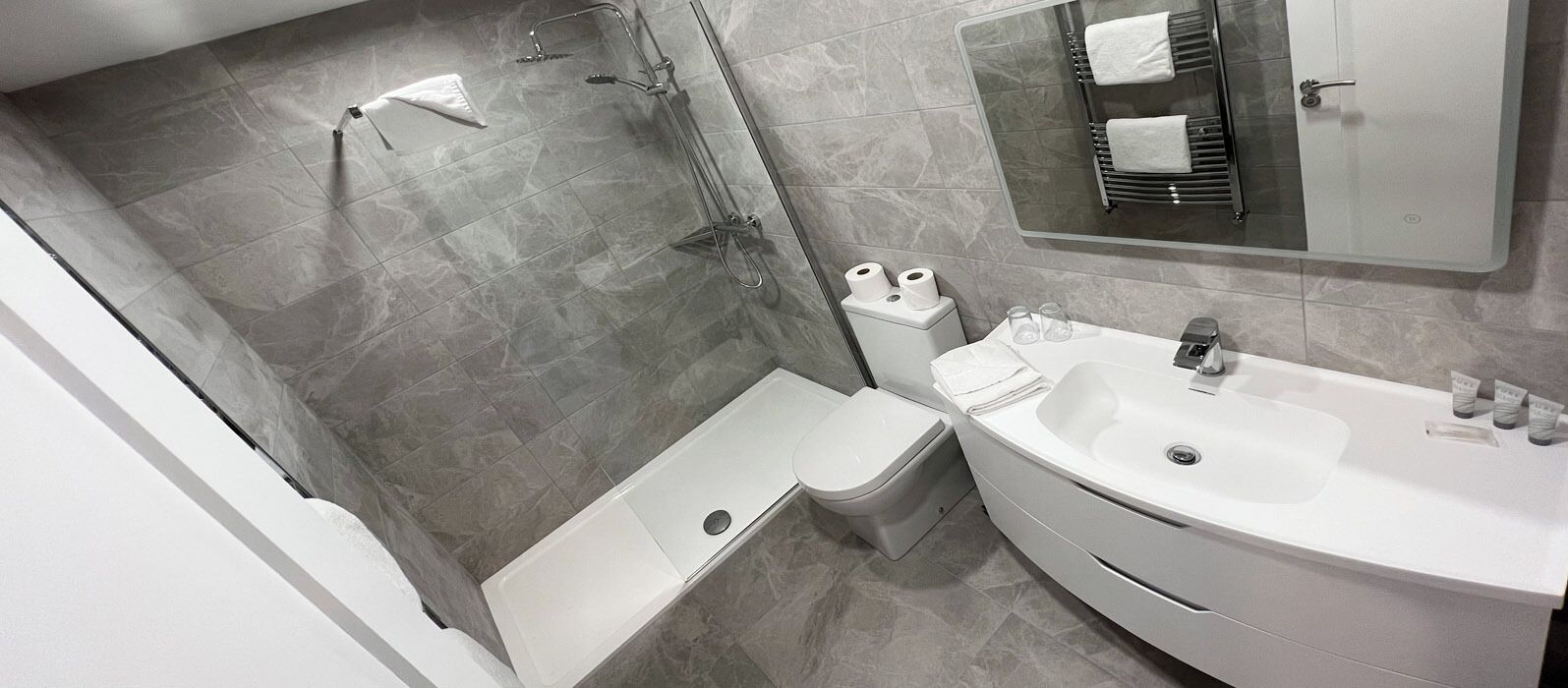 Un baño moderno con ducha, inodoro y lavamanos.