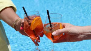 Two people holding glasses of a beverage with a straw, near a pool. - Hotel Lord Byron (Forio)
