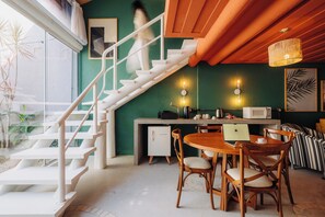 A modern kitchen with a white refrigerator, a microwave, and a laptop on the counter. - Own Buzios Beach Hotel (Búzios)