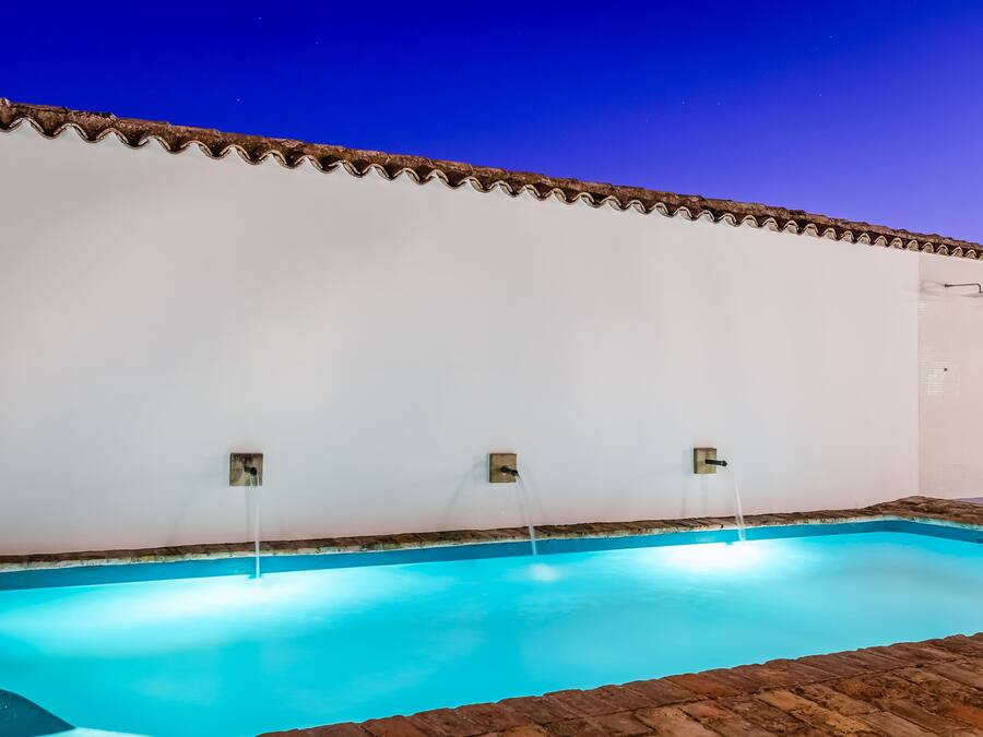 Una piscina con borde de azulejos y un borde de ladrillo.
