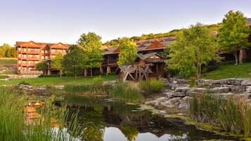Uma pousada com vários edifícios, um lago e vegetação ao redor.