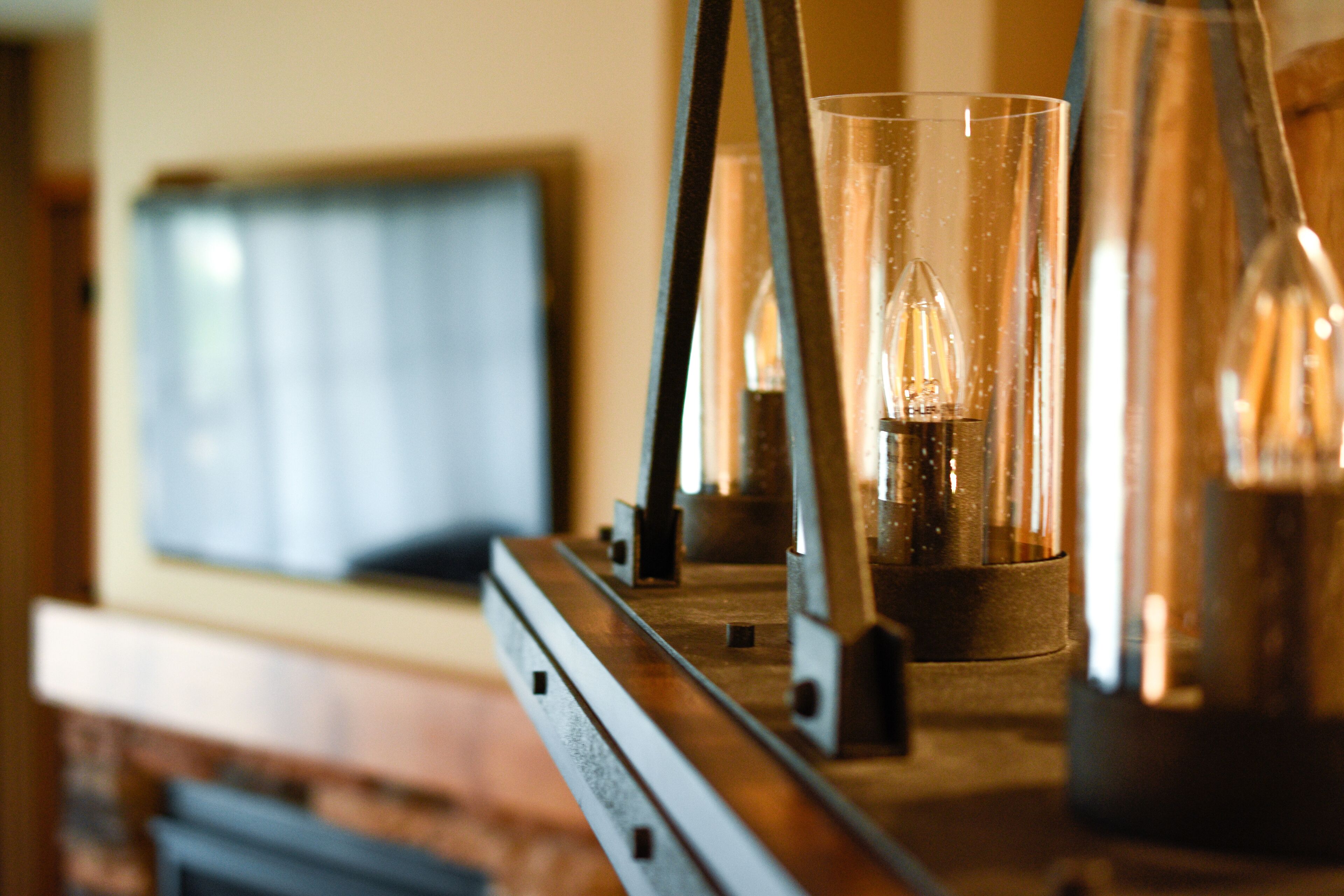 A modern interior with a fireplace, a mounted television, and a bar area with glasses and bottles.