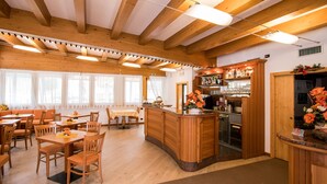 Un intérieur en bois comprenant un bar, des tables et des chaises.