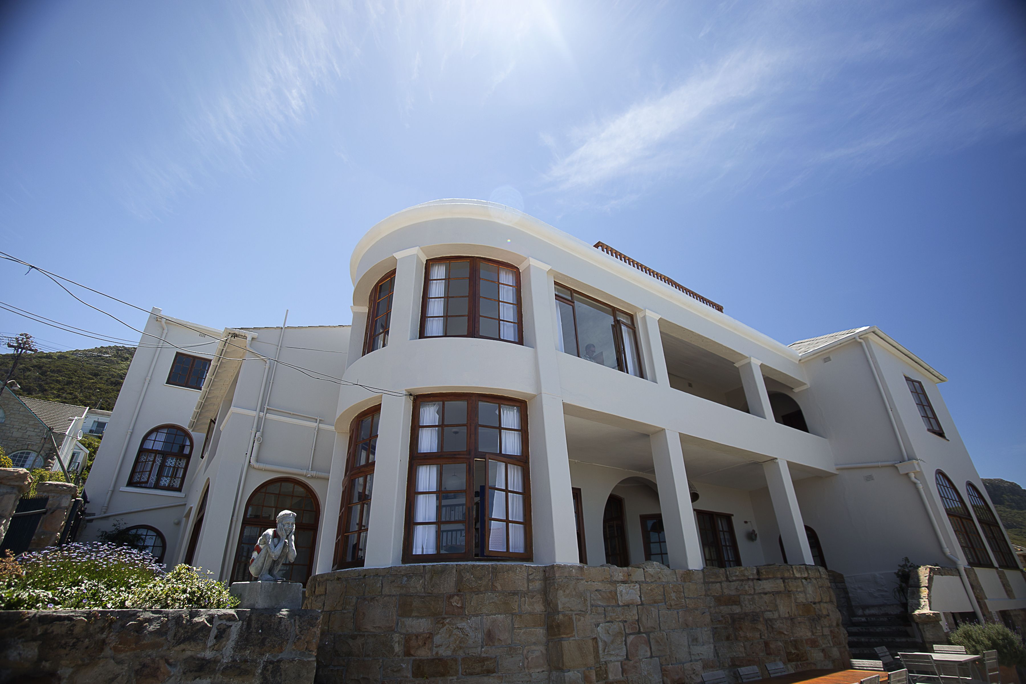 A two-story building with a curved facade, large windows, and a stone base.