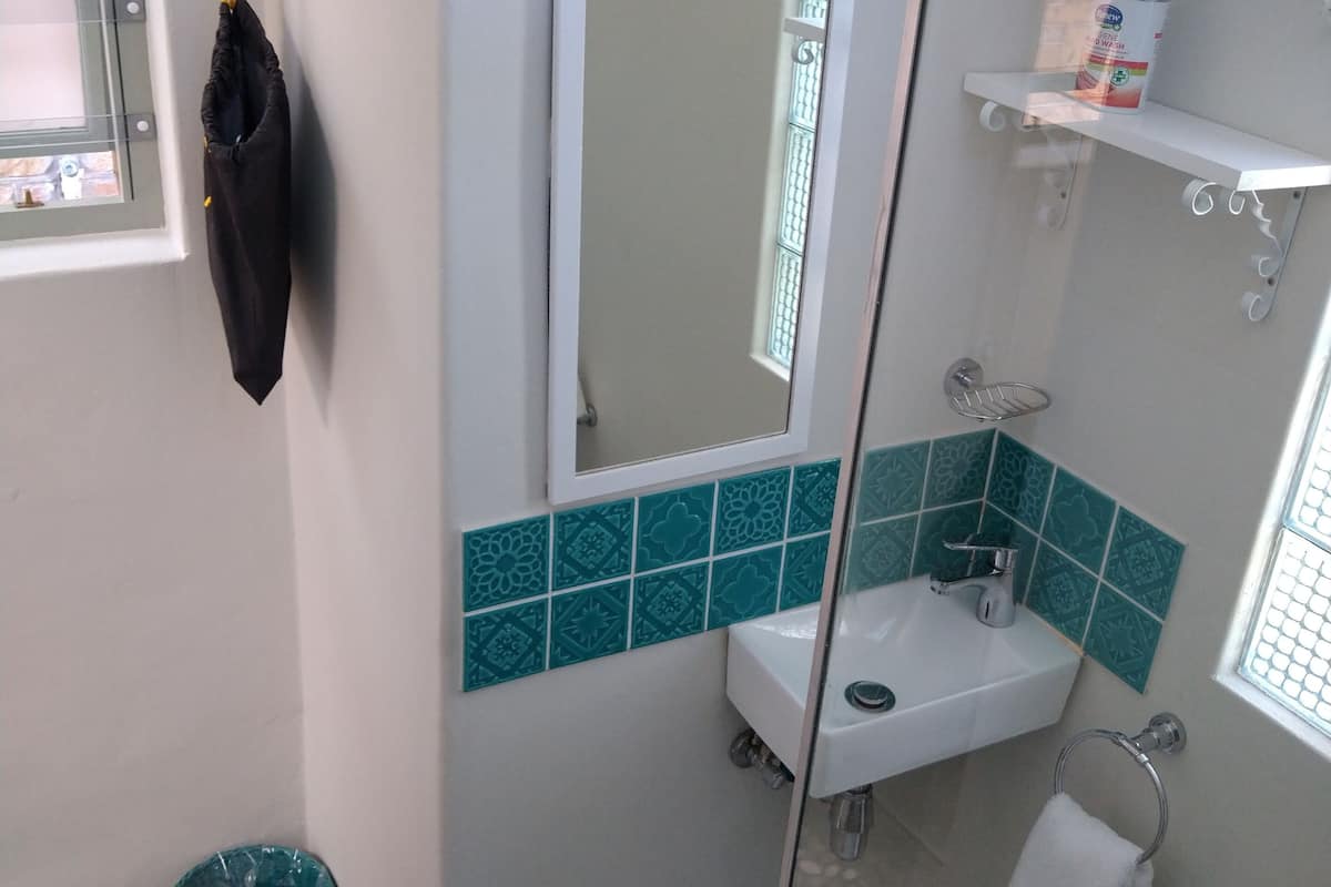 Ein Badezimmer mit Waschbecken, Spiegel und Handtuchhalter.