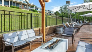 A patio area with outdoor seating, a fire feature, and a view of a residential building. - WorldMark New Braunfels (New Braunfels)