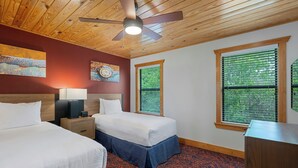 A hotel room with two beds, a ceiling fan, artwork on the wall, and windows with blinds. - WorldMark New Braunfels (New Braunfels)