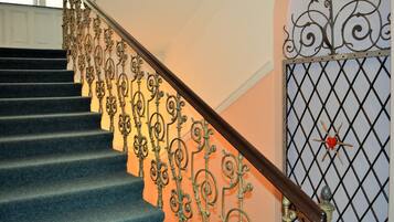 Una escalera con barandillas de metal decoradas y una barandilla de madera.
