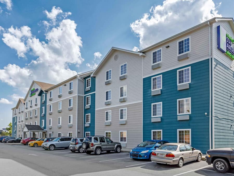 A multi-story hotel with a parking lot in front.