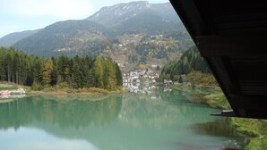 Un lago con un pueblo al fondo, rodeado de montañas.