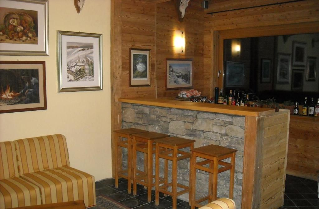 Een gezellige zithoek met een stenen open haard, een houten bar en gestreepte banken.