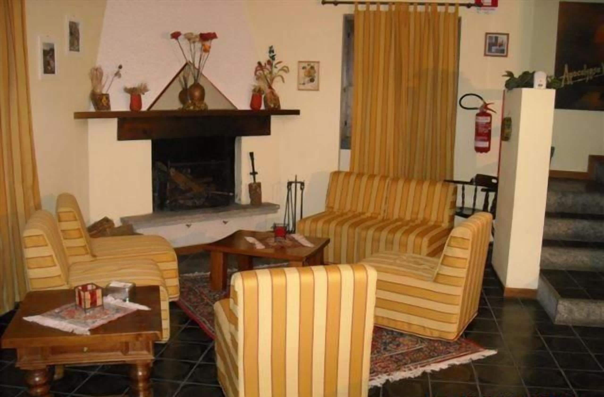 Un salon chaleureux avec des fauteuils à rayures, une table basse en bois et une cheminée.