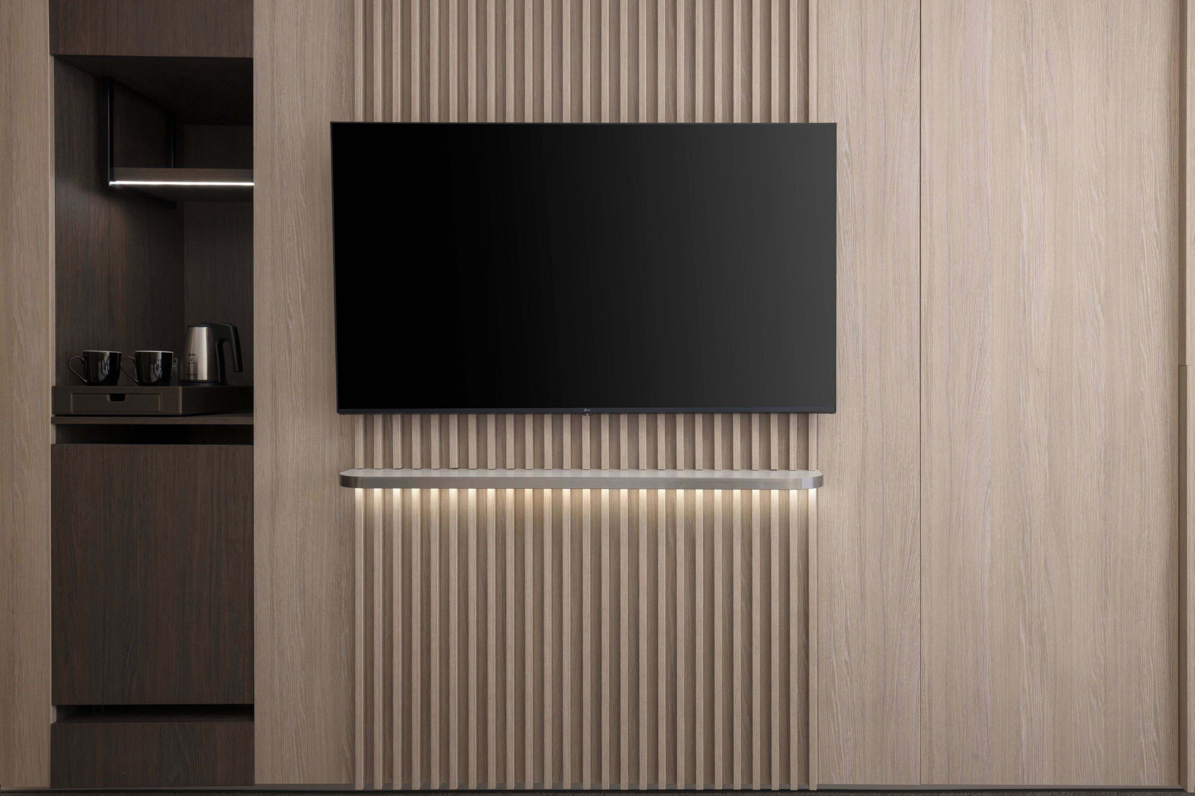 Una cocina moderna con televisor de pantalla plana integrado, cafetera y encimera elegante.