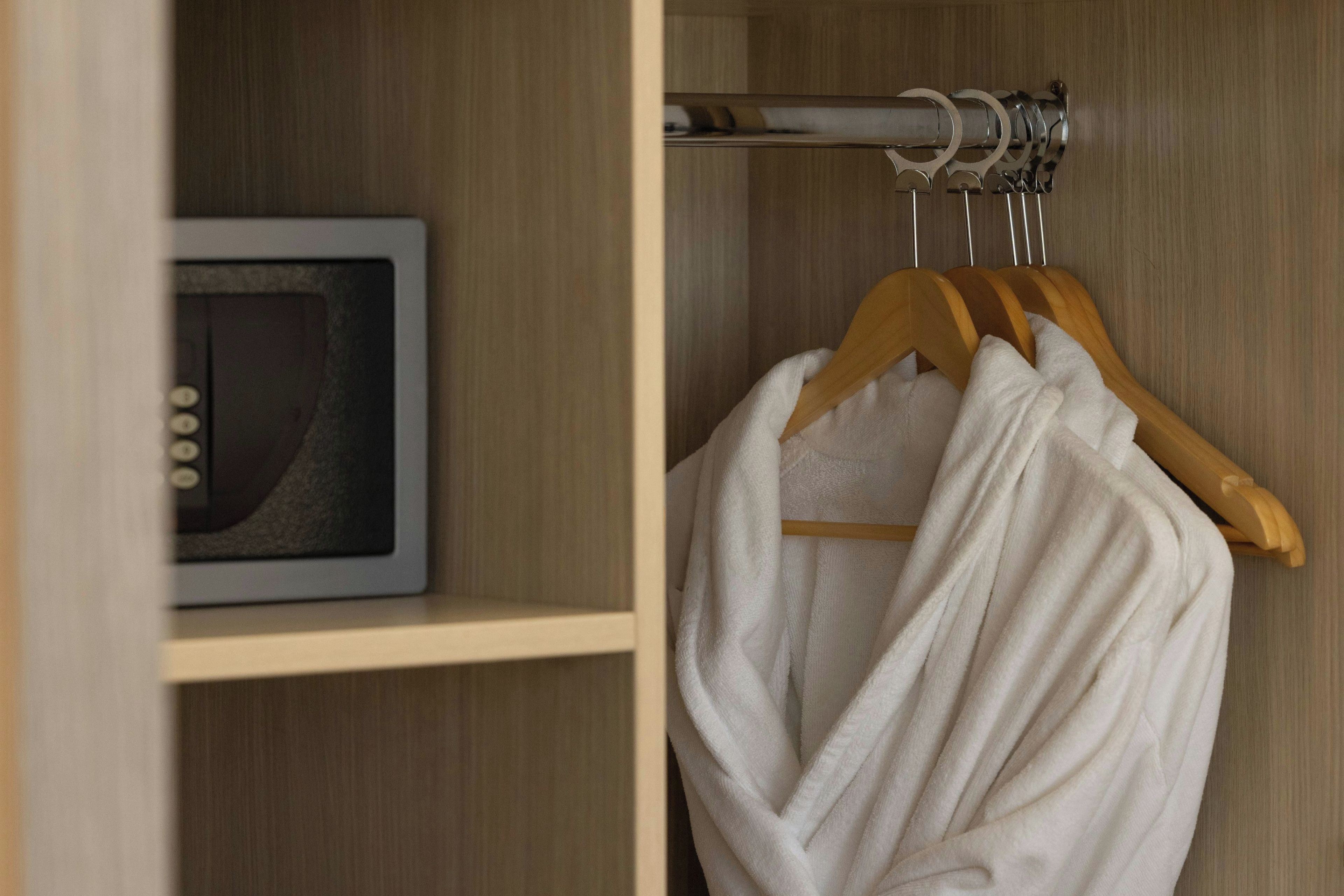 Een houten garderobe met een kledingroede en een plank.