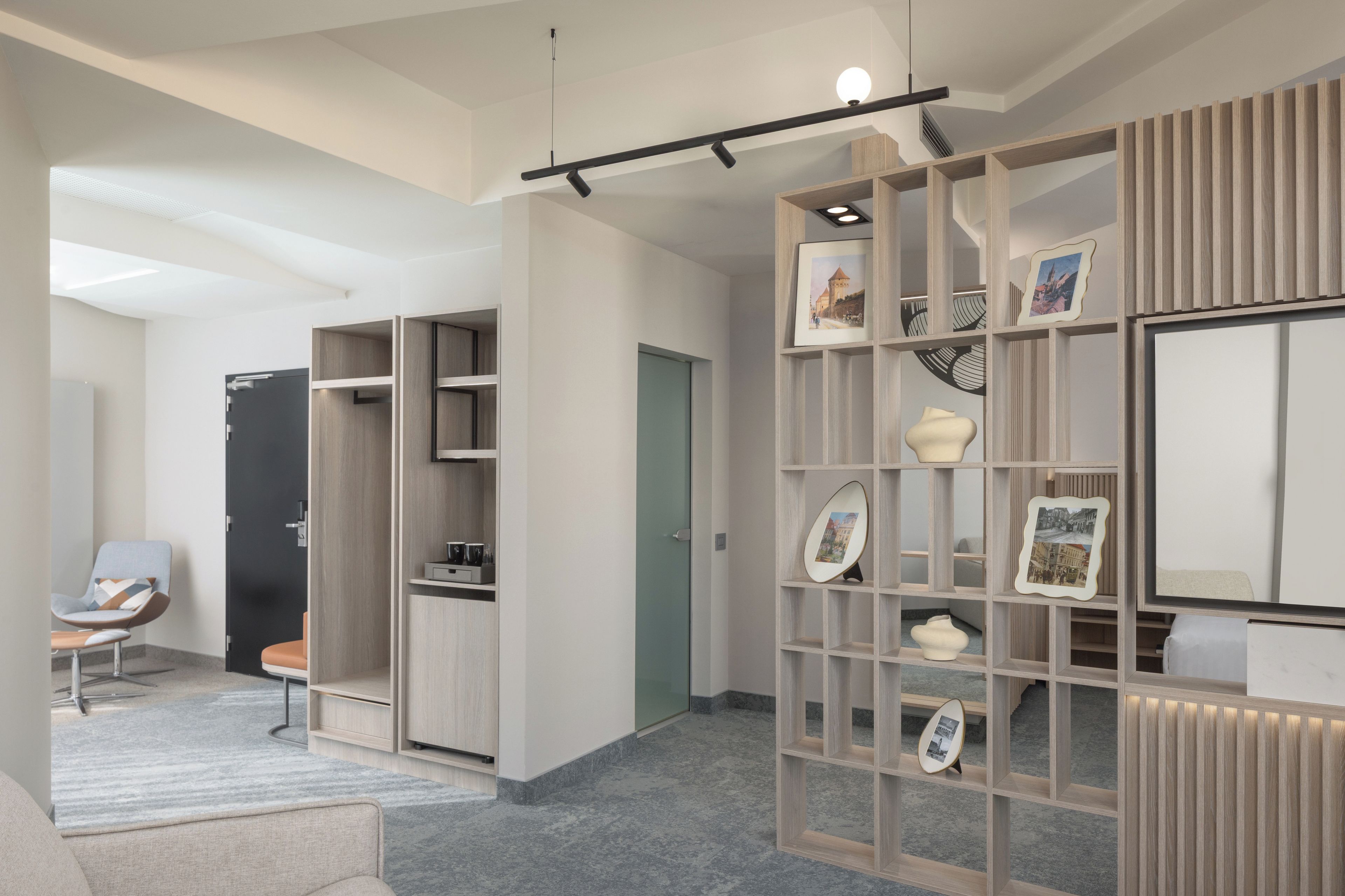 A modern interior with a built-in bookshelf, a seating area with a chair, and a door leading to another room.