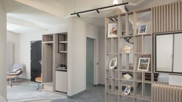 A modern interior with a built-in bookshelf, a seating area with a chair, and a door leading to another room.