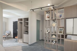 A modern interior with a built-in bookshelf, a seating area with a chair, and a door leading to another room.