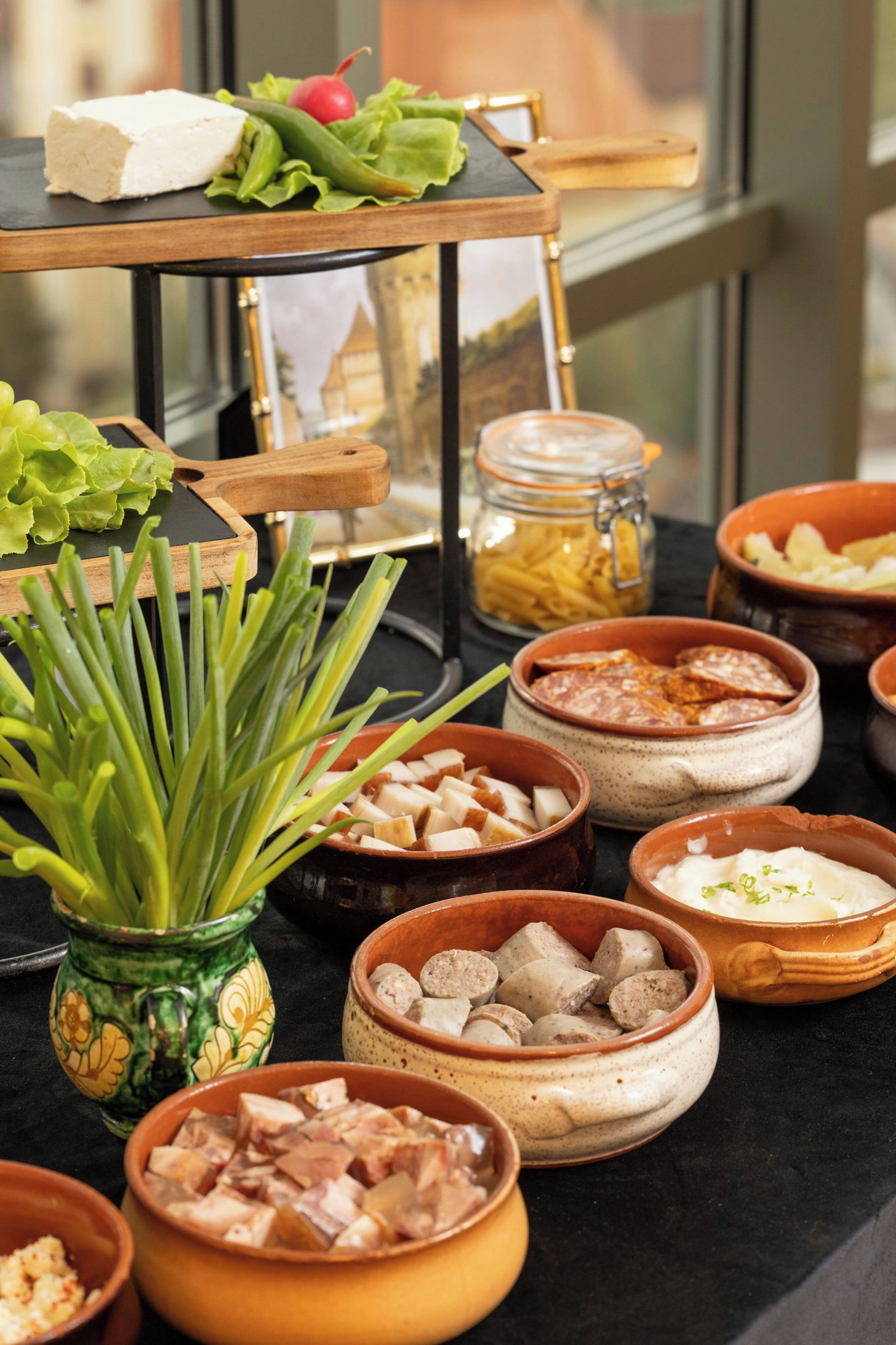 Una mesa de buffet con diversos alimentos y una planta decorativa.