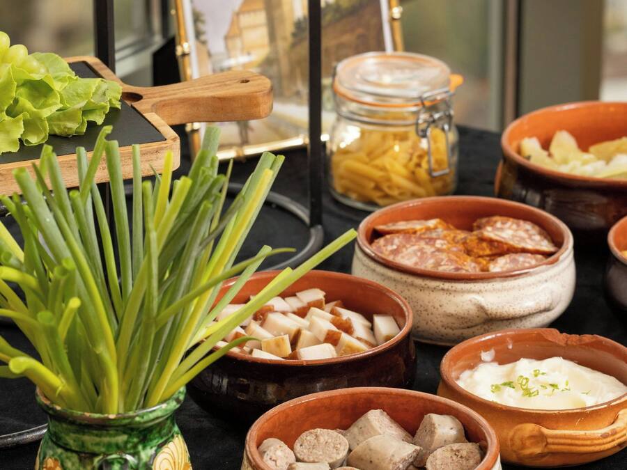 Una mesa de buffet con diversos alimentos y una planta decorativa.