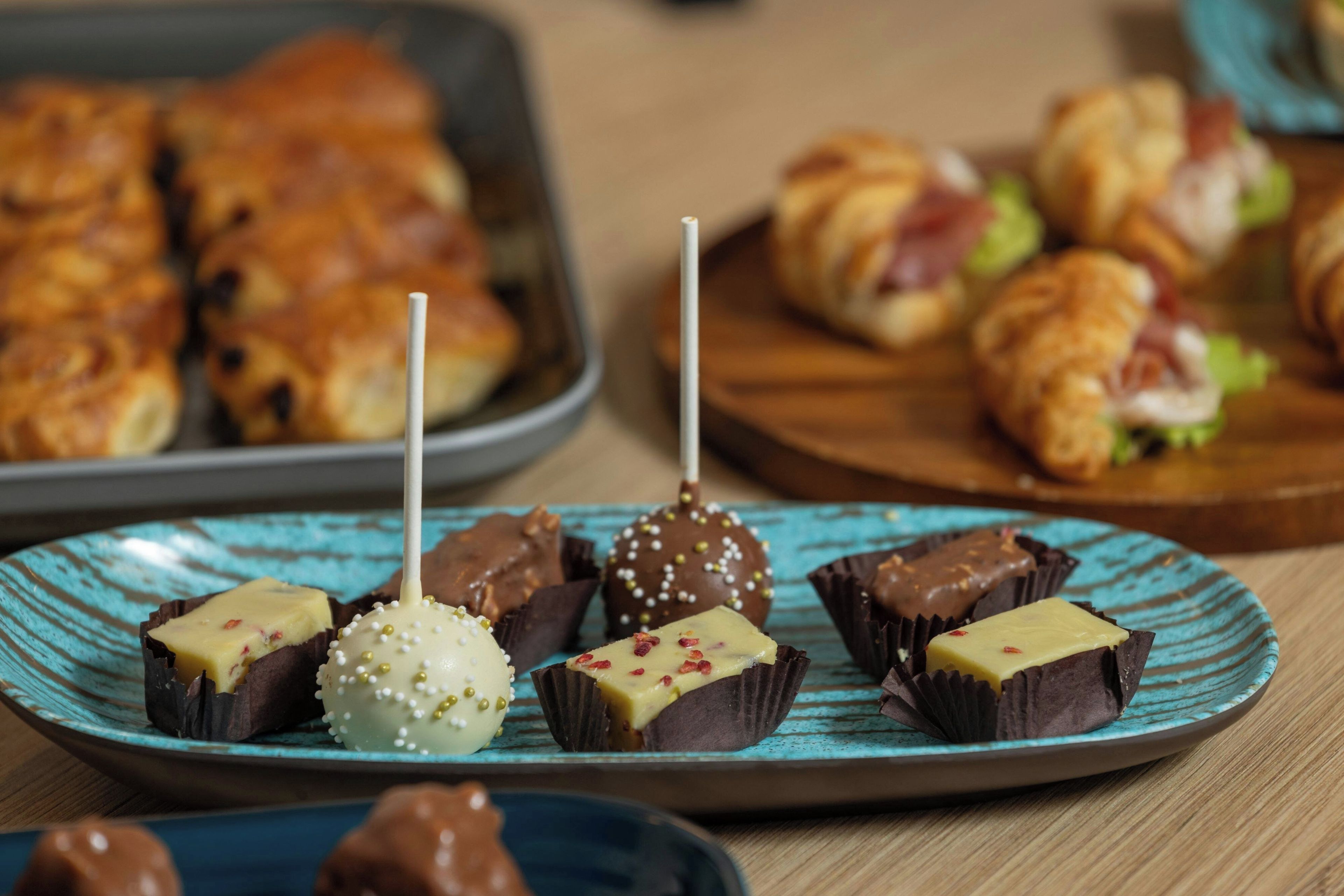 A variety of desserts on a plate, including chocolate-covered treats and a pastry.