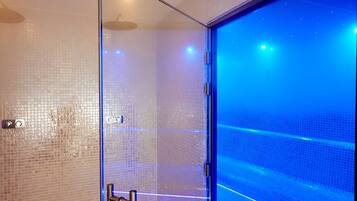 Enjoy a refreshing shower in this sleek shower area with a glass partition and a showerhead.