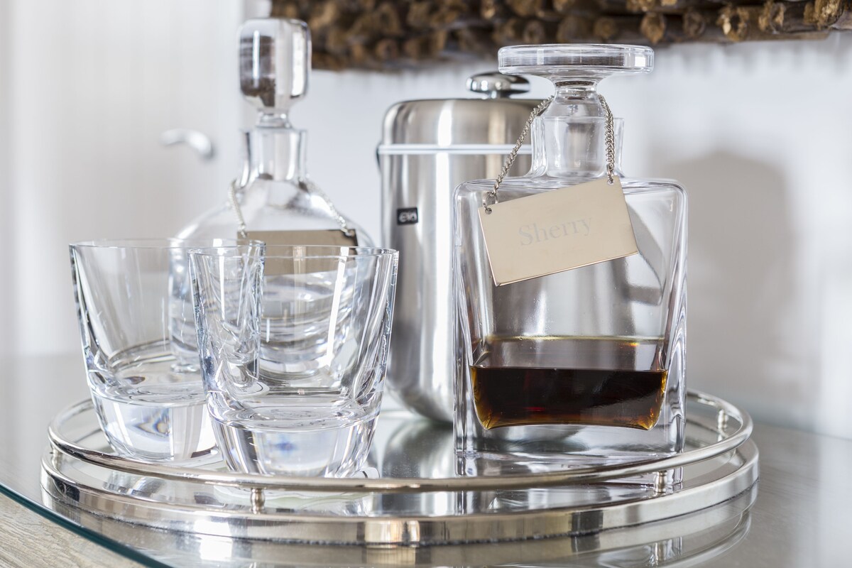 A tray with a decanter, a carafe, and several glasses.