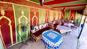 Una habitación con pared estampada, un sofá, una mesa con mantel y una lámpara colgante.
