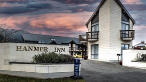 A hotel named 'HANMER INN' with a modern architectural design, featuring a prominent entrance and a balcony. - ASURE Hanmer Inn Motel (Hanmer Springs)